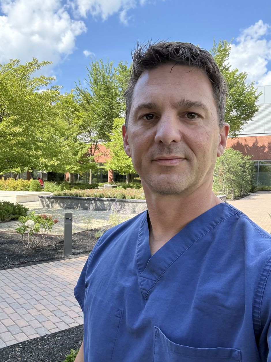 Brian Wallace, PA-C, in scrubs on the hospital campus